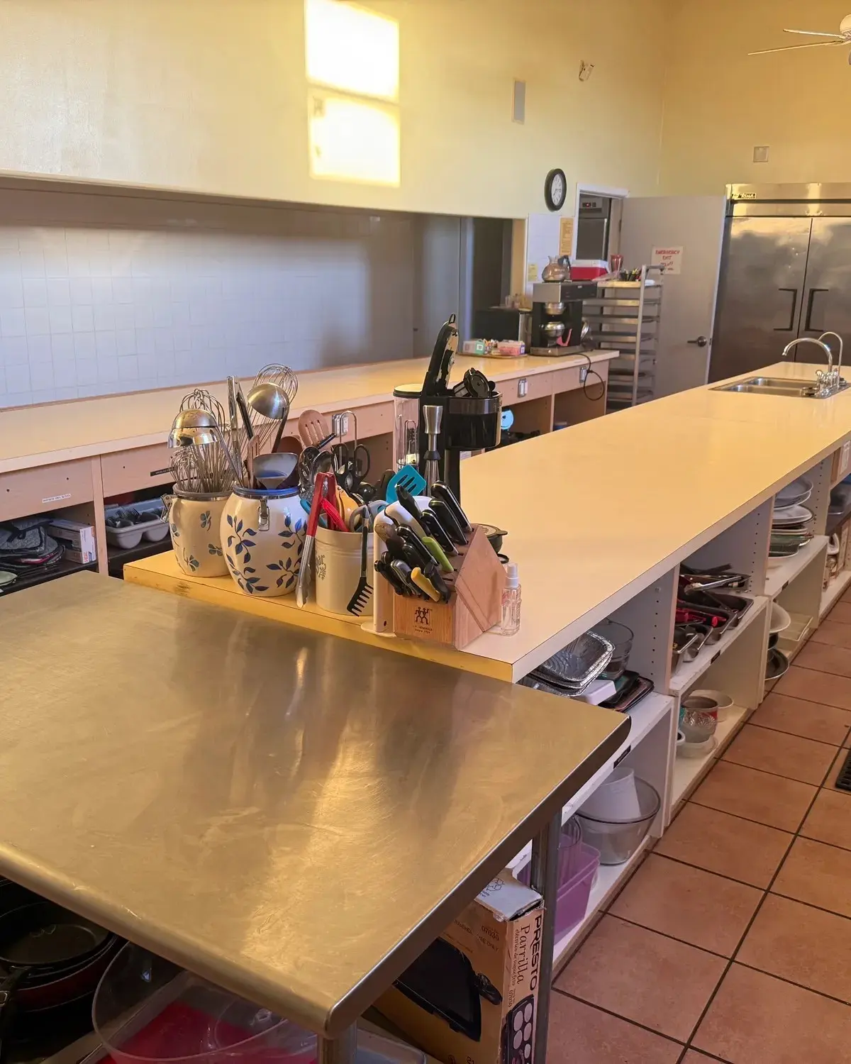 Commercial kitchen with a long stainless prep table and walk-in refrigeration